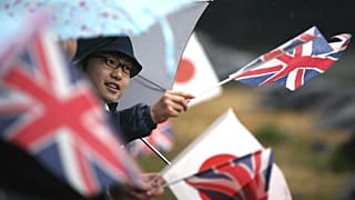 A student waves flags of Britain and Japan 