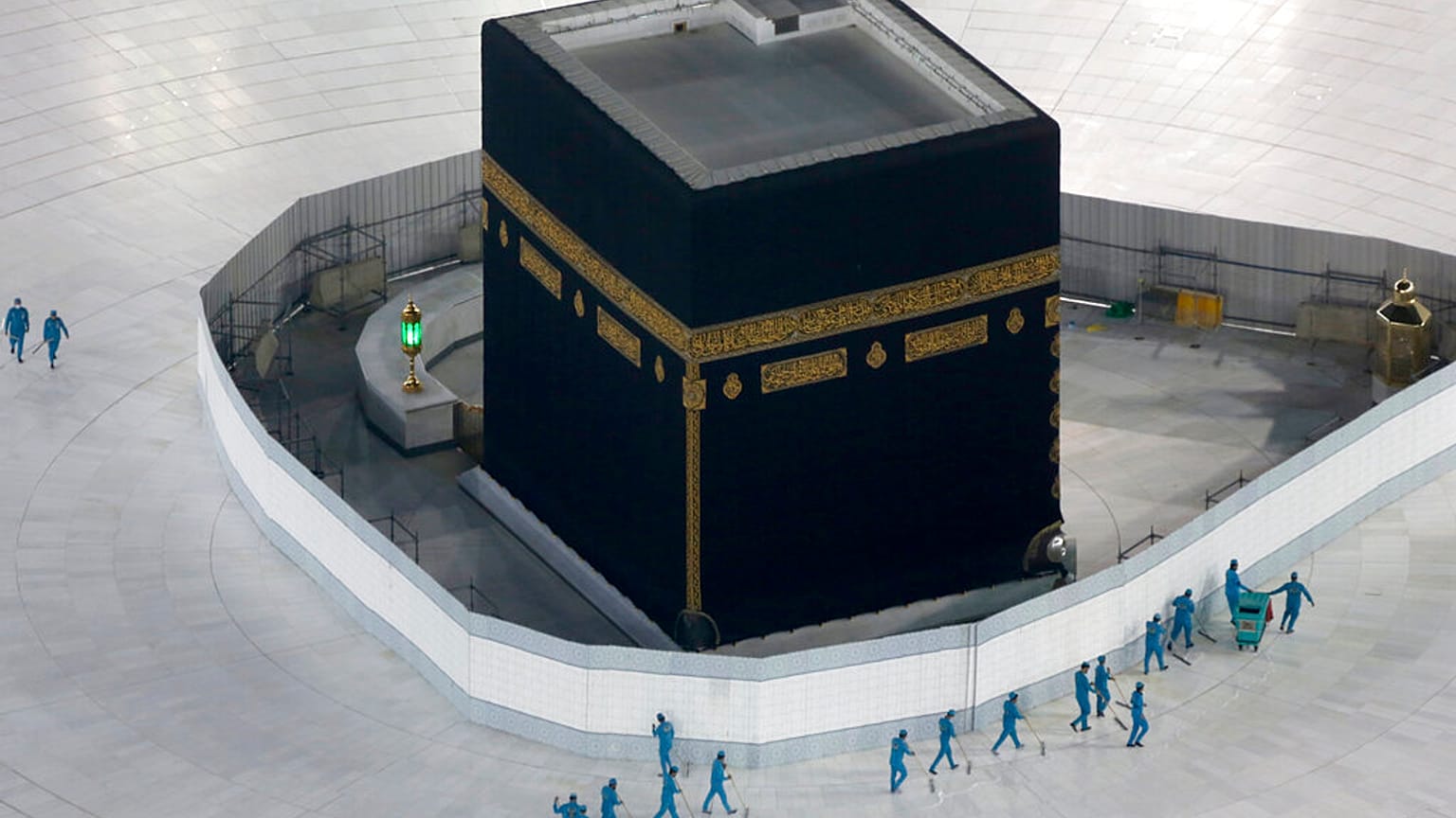workers disinfect the ground around the Kaaba