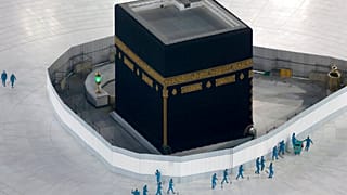 workers disinfect the ground around the Kaaba