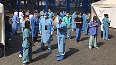 Juarez public hospital health workers wait on a street after a 7.5 earthquake sent them out from their work areas, in Mexico City, Tuesday, June 23, 2020. 