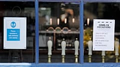 Draft tabs are seen through a window of a closed pub in London, Tuesday, June 23, 2020. Pubs are to reopen in a major easing of lockdown restrictions in England from July 4.