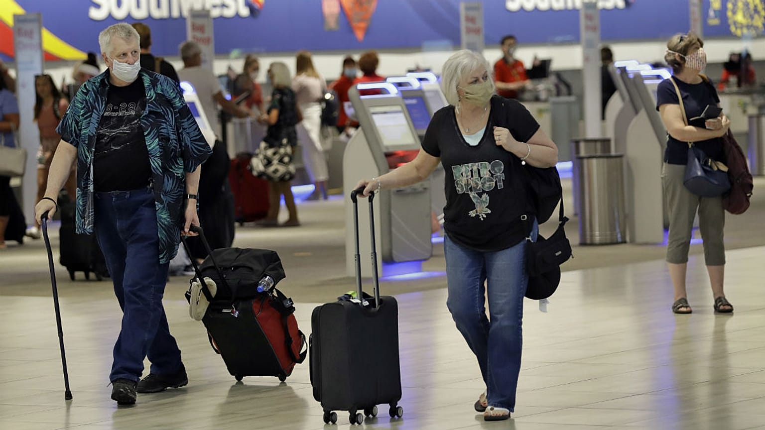 	Tampa, FLORIDA, UNITED STATES,Passengers wearing personal protective face masks walk past the Southwest Airlines ticket counter 
