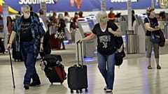 	Tampa, FLORIDA, UNITED STATES,Passengers wearing personal protective face masks walk past the Southwest Airlines ticket counter 