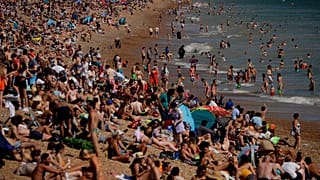 On Britain's hottest day of the year so far with temperatures reaching 32.6 degrees at Heathrow, people relax on Brighton Beach in Brighton, England, Wednesday
