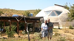 Laura Davies and Dave Buchanan standing outside their eco home.