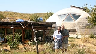 Laura Davies and Dave Buchanan standing outside their eco home.