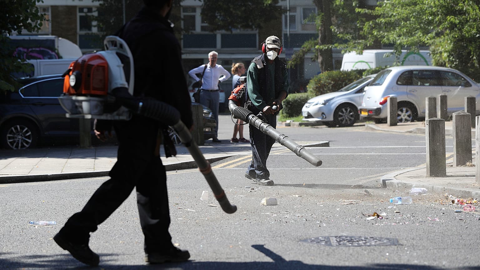 Volunteers clean up the streets following overnight violent confrontations in Brixton, London.