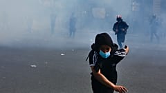 A protestor flees tear gas