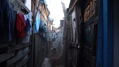 Volunteers spreading disinfectant in alleyways of squat 