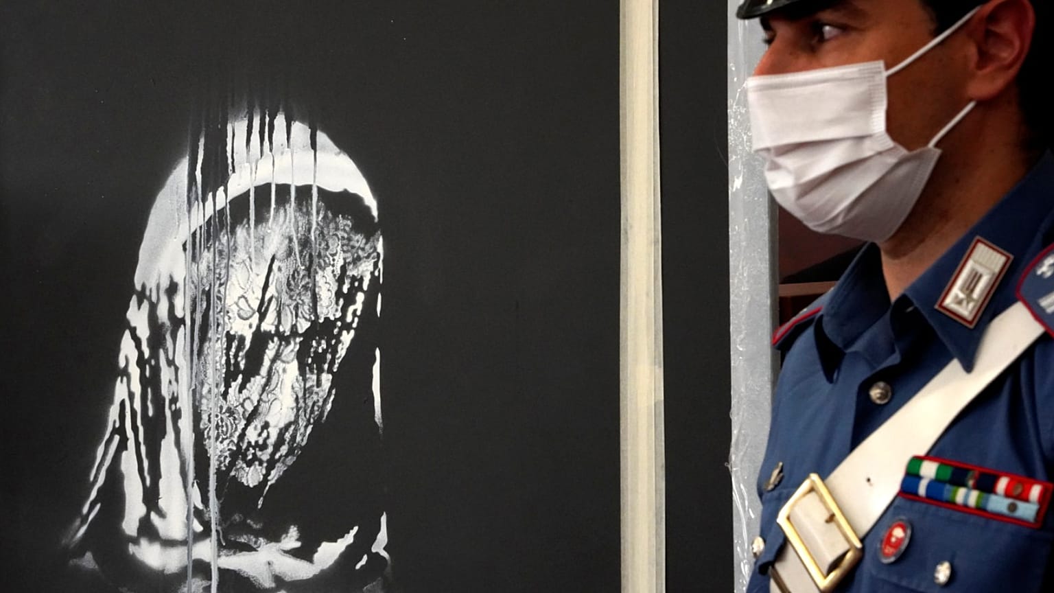 Italian police guard the recovered Banksy's artwork in L'Aquila, Italy, Thursday June, 11, 2020