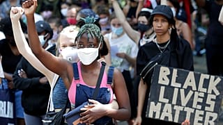 Deux jeunes femmes participent à un rassemblement contre le racisme à Berlin