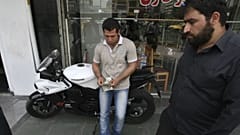 A street money exchanger, center, counts US dollars, in downtown Tehran, Iran