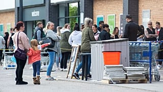People queue outside a shop in Leicester amid coronavirus social-distancing measures
