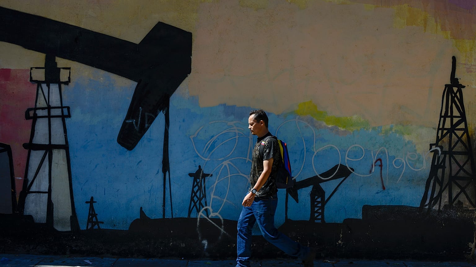 Un hombre pasa ante un mural en Caracas, Venezuela