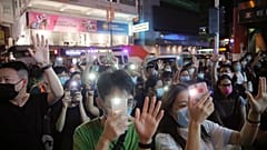 Protesters gesture with five fingers, signifying the "Five demands - not one less" during a protest in Mong Kok, Hong Kong, Friday, June 12, 2020. 