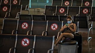 A passenger sits at Barcelona airport in Barcelona, Spain