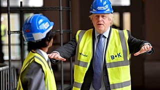 Britain's Prime Minister Boris Johnson talks with year 10 pupil Vedant Jitesh during a visit to the construction site of Ealing Fields High School in London, June 29, 2020.