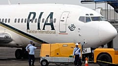 A Pakistan International Airlines passenger jet is parked on the tarmac at a military base in Makassar, Indonesia.