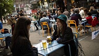 European tourists drinks beers at the terrace of the Bar du Matin restaurant in Brussels