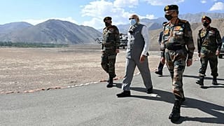 In this handout photo provided by the Press Information Bureau, Indian Prime Minister Narendra Modi walks with soldiers during a visit to the Ladakh area, India, Friday, July