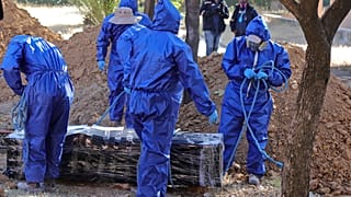 Trabajadores se preparan para enterrar a un fallecido por COVID-19 en Cochabamba