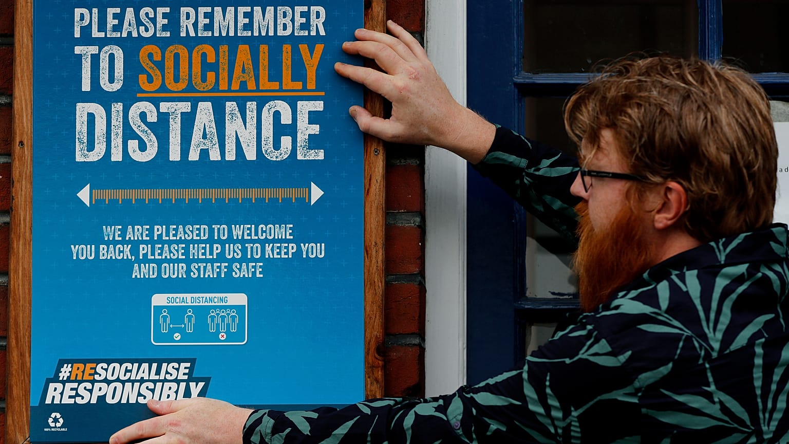A pub owner put signs in place instructing on social distancing at the Chandos Arms pub in London, Wednesday, July 1, 2020.
