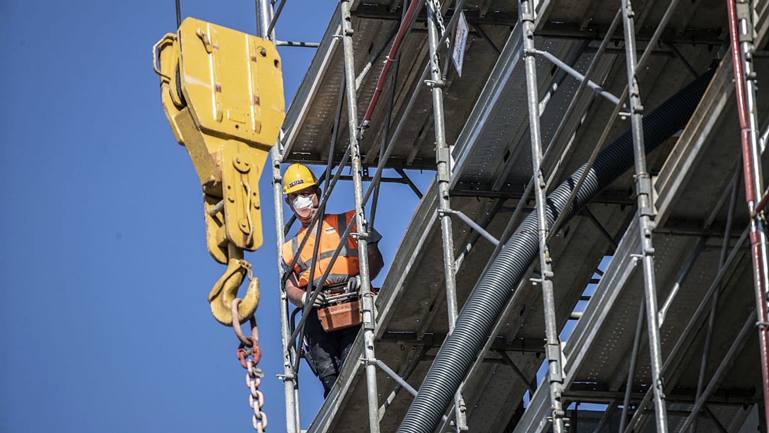 A worker operates at a construction site in Milan, Italy