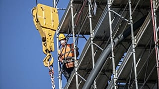 A worker operates at a construction site in Milan, Italy