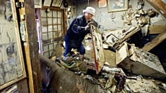 A man looks for his medicine at the house damaged by floods provoked by heavy rains in Hitoyoshi, Kumamoto prefecture, southern Japan. July 12, 2020