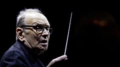 In this file photo dated Tuesday, March 6, 2018, Italian composer Ennio Morricone directs an ensemble during a concert of his "60 Year Of Music World Tour", in Milan, Italy