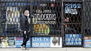 A man walks by a closed store during the COVID-19 in Chicago