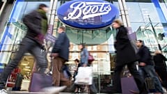 FILE - In this Oct. 5, 2005 file photo, people walk past a Boots pharmacy in central London.