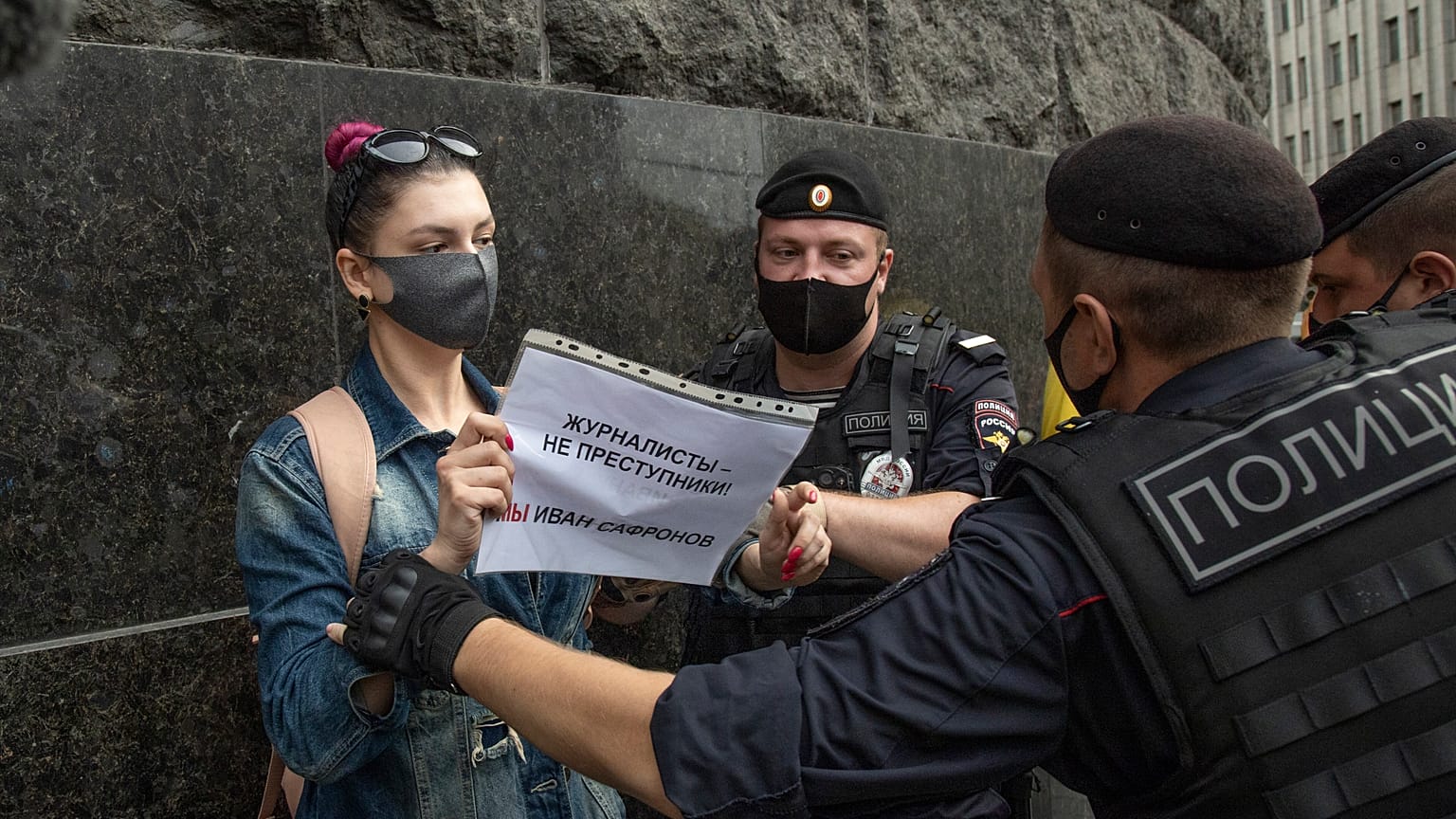 A journalist from the RT television channel holds a poster reading "Journalists are not criminals! We are Ivan Safonov" during a protest outside the FSB headquarters in Moscow