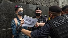 A journalist from the RT television channel holds a poster reading "Journalists are not criminals! We are Ivan Safonov" during a protest outside the FSB headquarters in Moscow