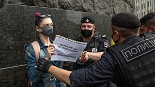 A journalist from the RT television channel holds a poster reading "Journalists are not criminals! We are Ivan Safonov" during a protest outside the FSB headquarters in Moscow