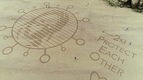 Dessins géants de sable contre le covid-19