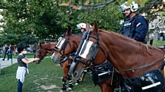 A rohamrendőrség lovát kényezteti egy járókelő Belgrádban