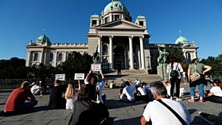 People sit during a protest in front Serbian Parliament building in Belgrade, Serbia,Thursday, July 9, 2020.