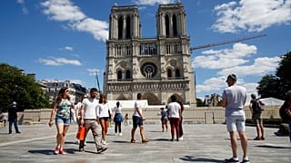People walk on the forecourt of Notre Dame's Cathedral, in Paris, Sunday, May 31, 2020.