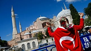People, draped in Turkish flags, chant slogans, outside the Byzantine-era Hagia Sophia