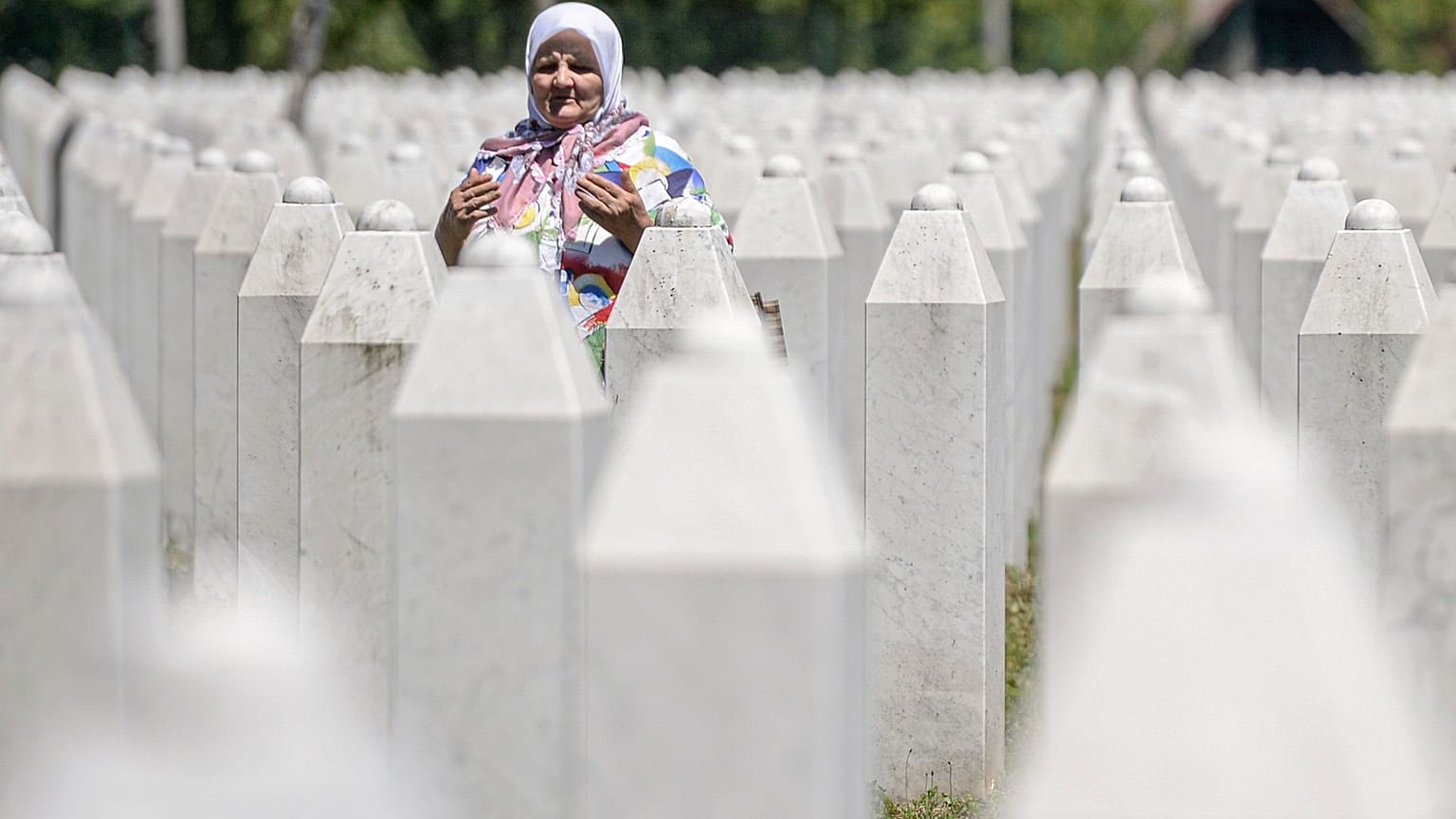 A woman prays at the memorial cemetery in Potocari, near Srebrenica, Bosnia.