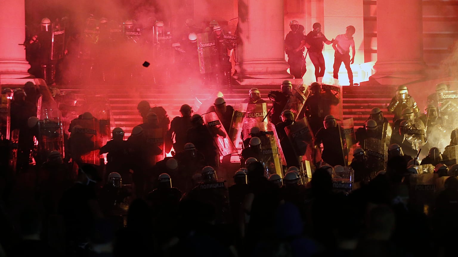 Protesters clash with riot police on the steps of the Serbian parliament during a protest in Belgrade, Serbia, Friday, July 10 2020. 
