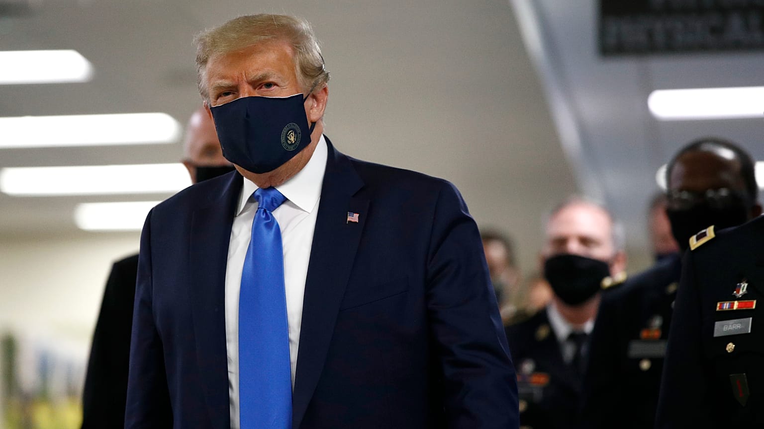 President Donald Trump wears a face mask as he walks down a hallway during a visit to Walter Reed National Military Medical Center in Bethesda, Md., Saturday, July 11, 2020.
