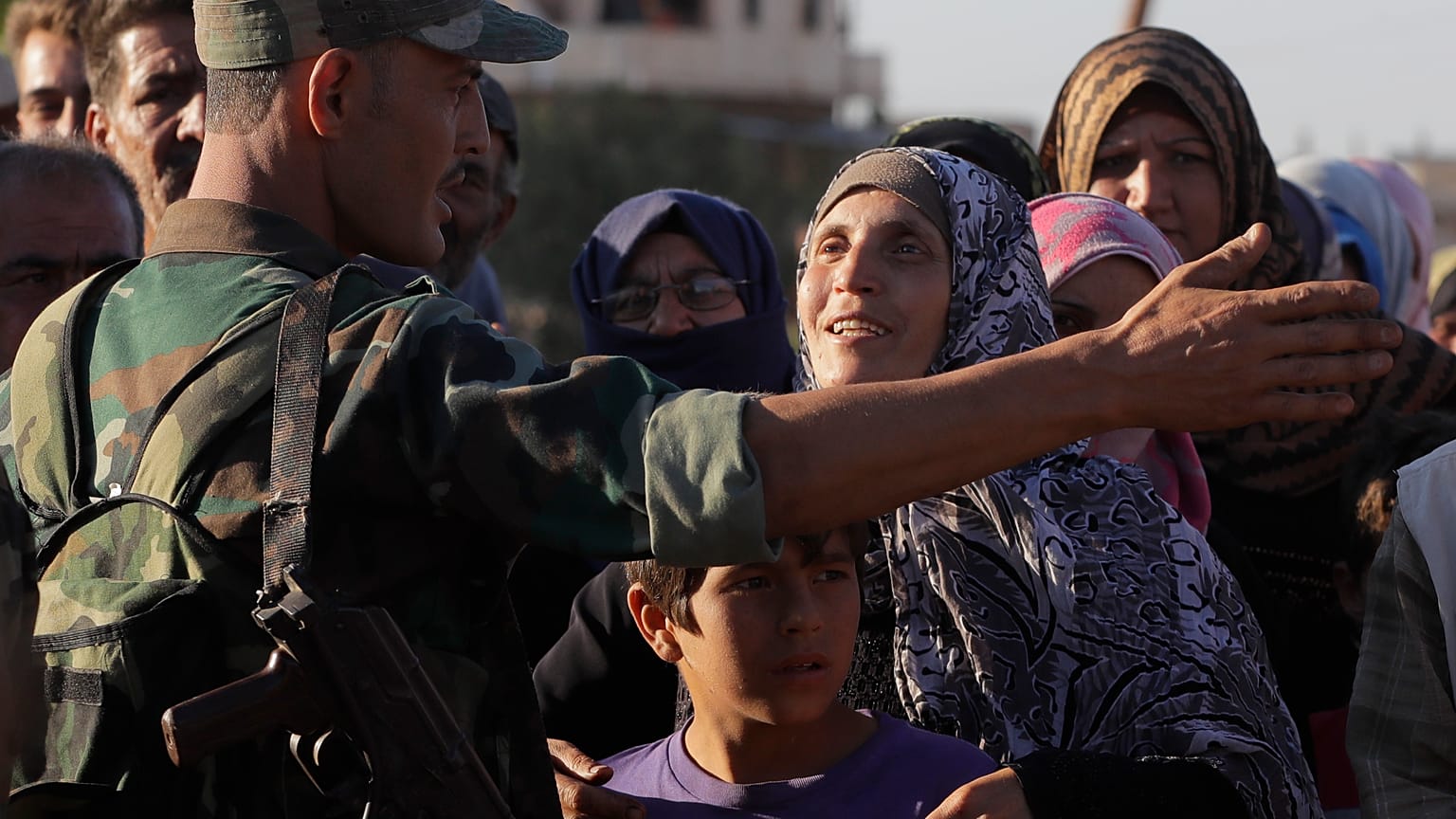 A woman talks with a soldier of the Syrian army during distribution of humanitarian aid from the Russian military in the town of Rastan, Syria, file photo, August 15, 2018.