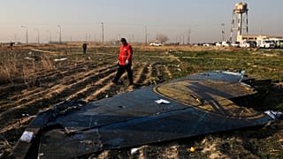 A rescue worker sifts through the wreckage of a Ukrainian plane shotdown in Tehran