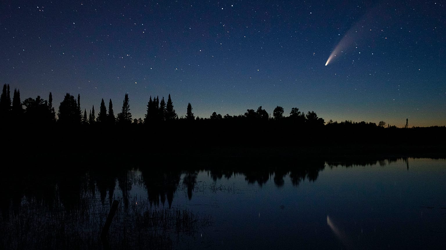 Comet Neowise streaks across the night sky over Wolf Lake in Brimson, Minnesota, USA. July 14, 2020