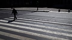 A man crosses an empty street during a nationwide confinement to counter the Covid-19, in Paris, Saturday, April 4, 2020.