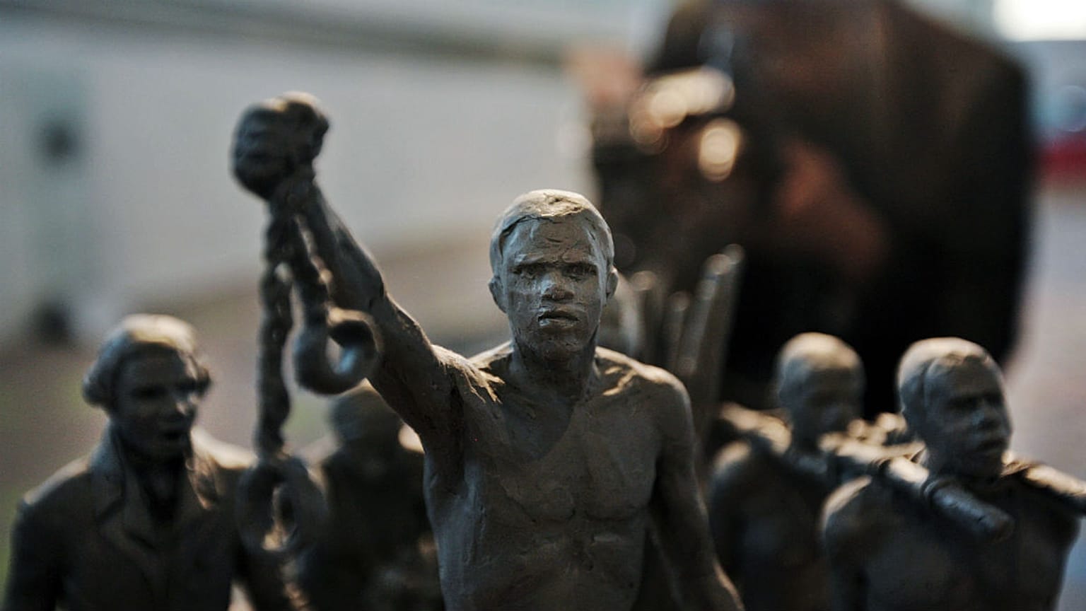 A man photographs a maquette of a status which stands as a permanent slavery memorial statue, City Hall, London