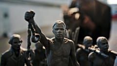 A man photographs a maquette of a status which stands as a permanent slavery memorial statue, City Hall, London