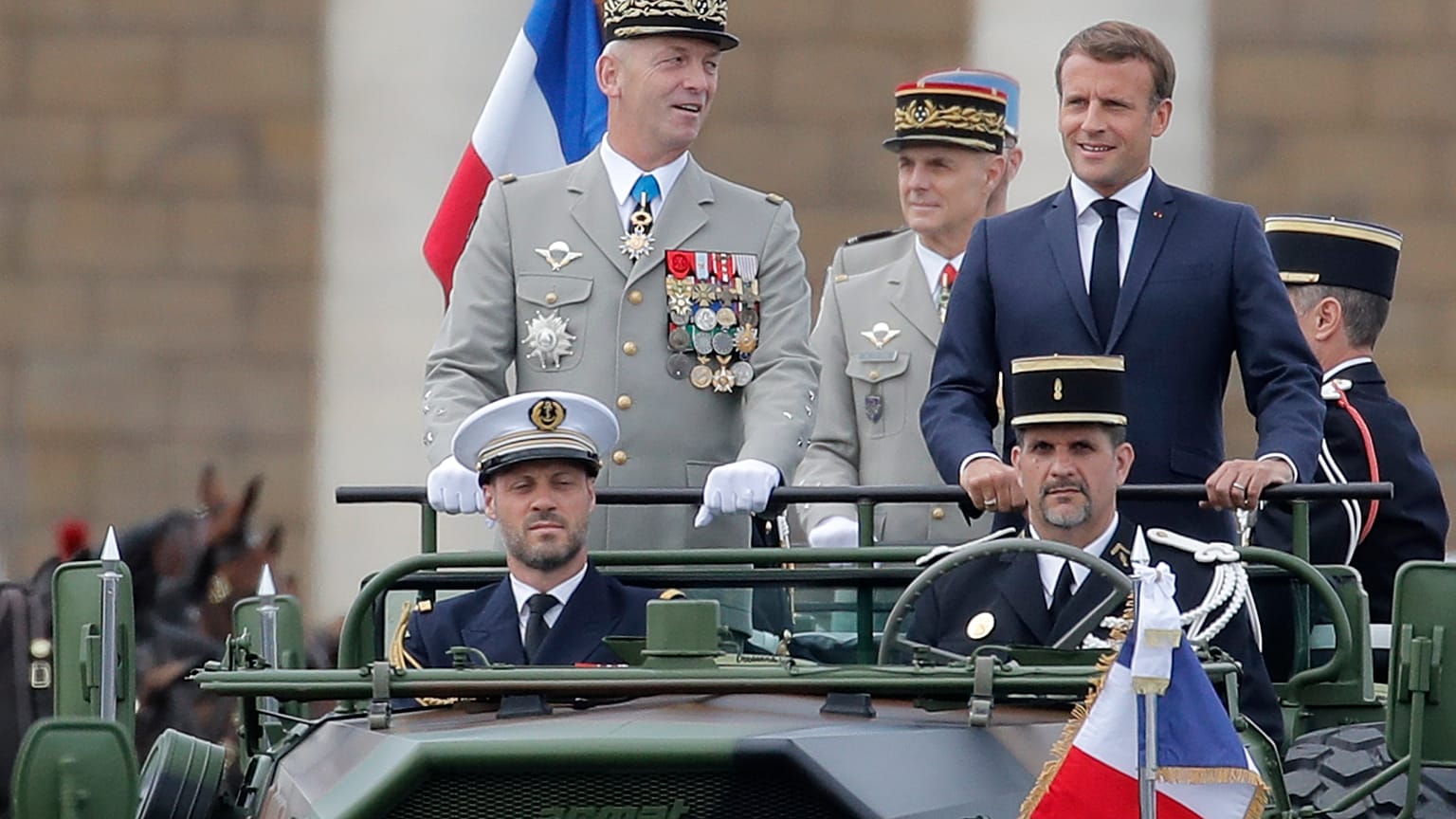 France's President Emmanuel Macron stands in the command car as he reviews troops before the start of the Bastille Day parade. 14 July, 2020.